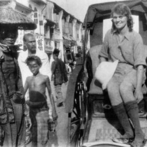 Woman sitting in rickshaw, street scene.