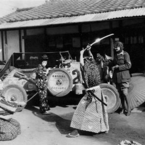 Samurai performance in front of vintage car.