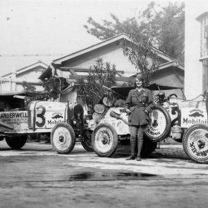 Vintage cars with person standing between them.