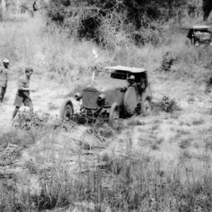 Vintage car stuck in a muddy terrain.