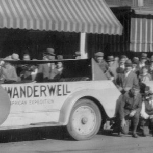 Vintage cars with crowd in background.