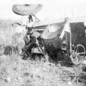 Overturned tractor in a grassy field.
