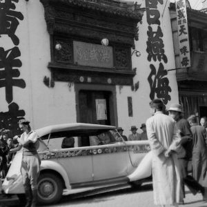 Vintage car parked on bustling street scene.