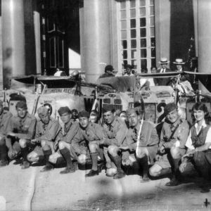 Group of men posing with vintage cars.