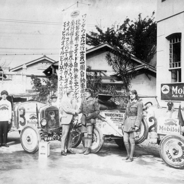 Vintage car race winners with trophy banner.